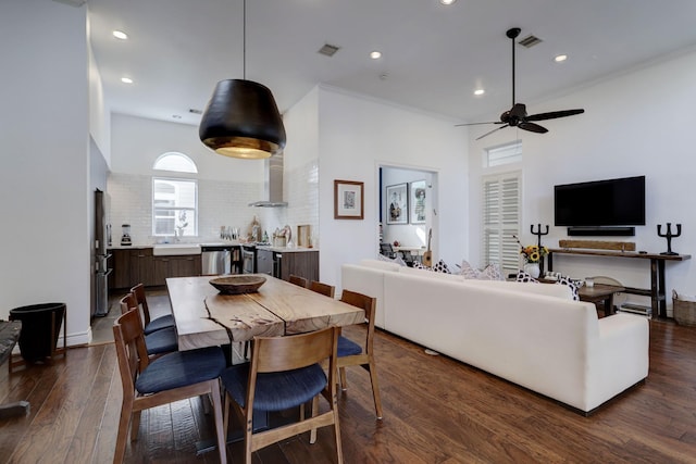 living room with plenty of natural light, ceiling fan, sink, and dark wood-type flooring