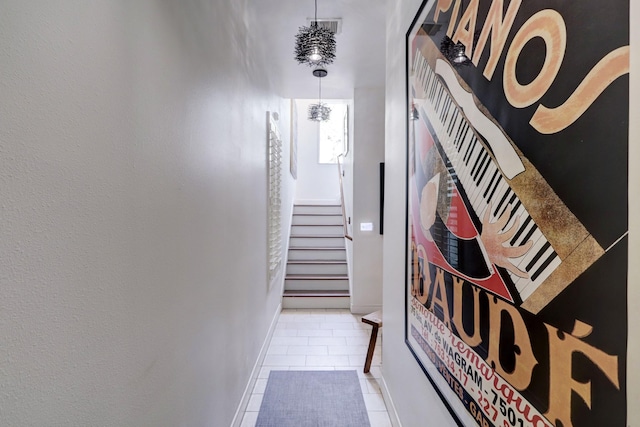 hall featuring a chandelier and tile patterned flooring