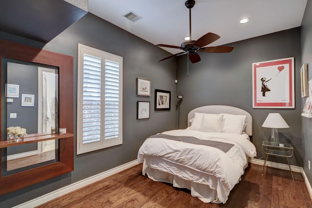 bedroom with multiple windows, ceiling fan, and hardwood / wood-style flooring