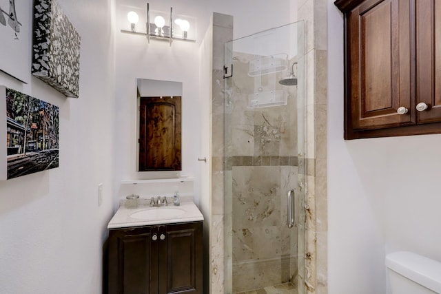 bathroom featuring vanity, toilet, and walk in shower