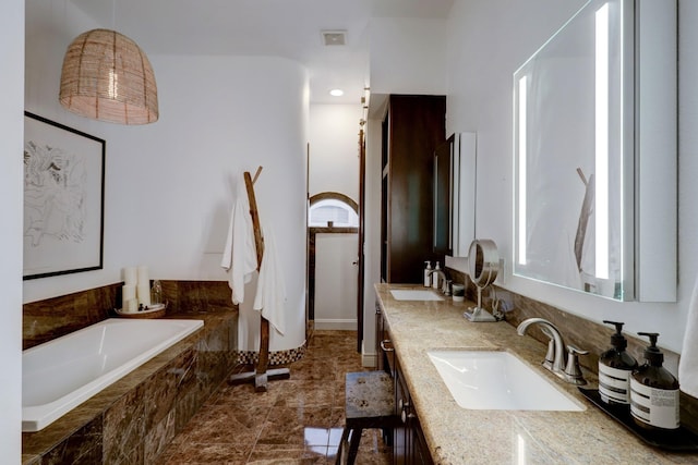 bathroom featuring vanity and a relaxing tiled tub