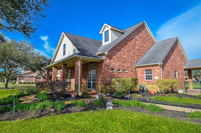 view of front facade featuring brick siding and fence