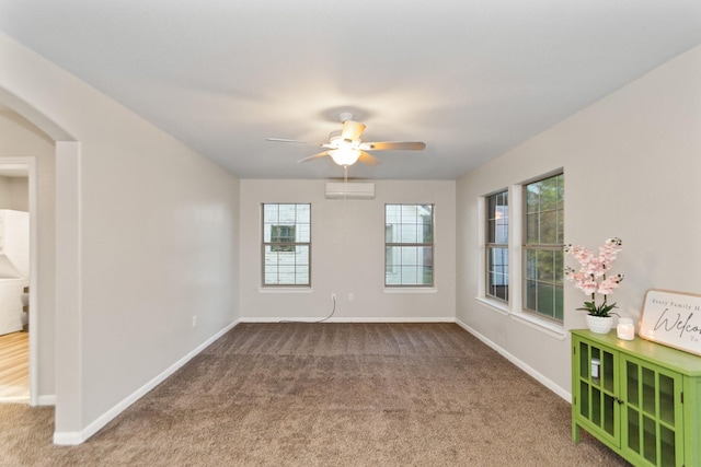 unfurnished room featuring carpet flooring, ceiling fan, and a wall unit AC