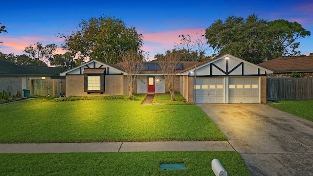 view of front facade featuring solar panels, a yard, and a garage