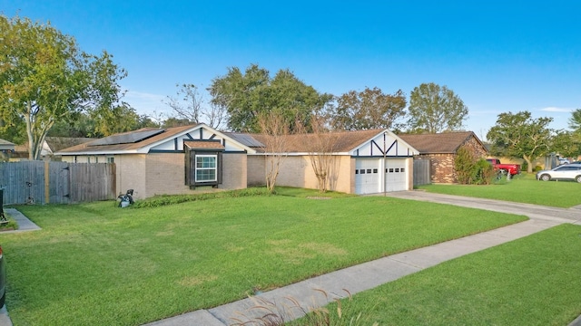 view of front of home featuring solar panels, a garage, and a front lawn