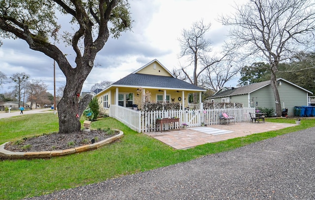 farmhouse-style home with ceiling fan, a patio area, and a front lawn