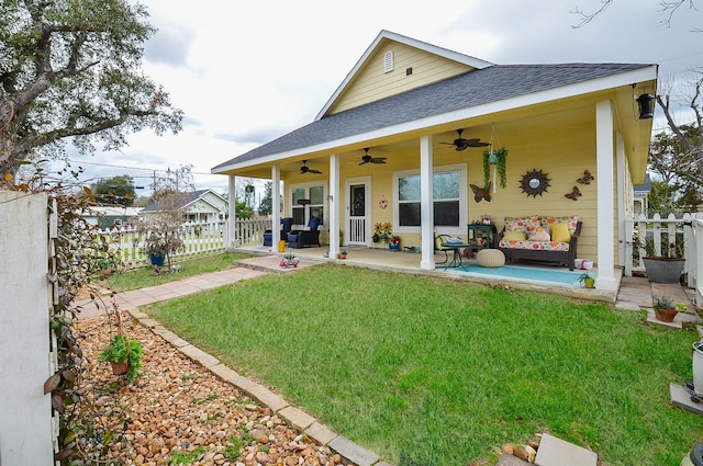 rear view of house featuring a porch, a yard, and ceiling fan