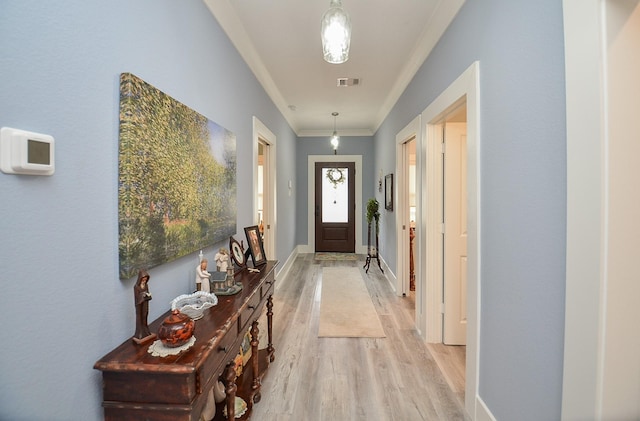 doorway with crown molding and light wood-type flooring