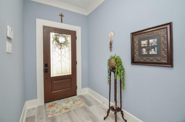 entryway with light hardwood / wood-style floors and crown molding