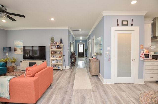 living room with ceiling fan, light wood-type flooring, and crown molding