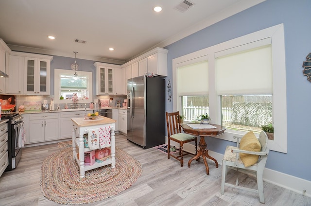 kitchen with a healthy amount of sunlight, a center island, stainless steel appliances, and decorative light fixtures