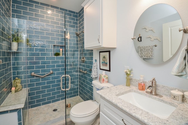 bathroom with vanity, toilet, and a shower with door