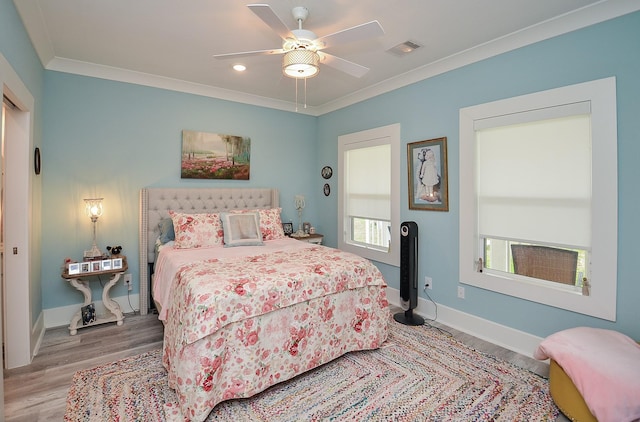 bedroom featuring hardwood / wood-style floors, ceiling fan, and crown molding