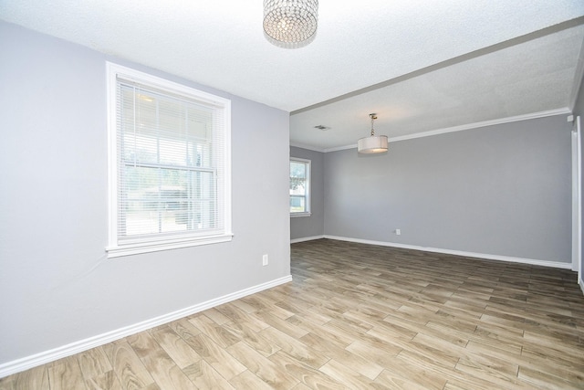 unfurnished room featuring crown molding, light hardwood / wood-style flooring, and a textured ceiling