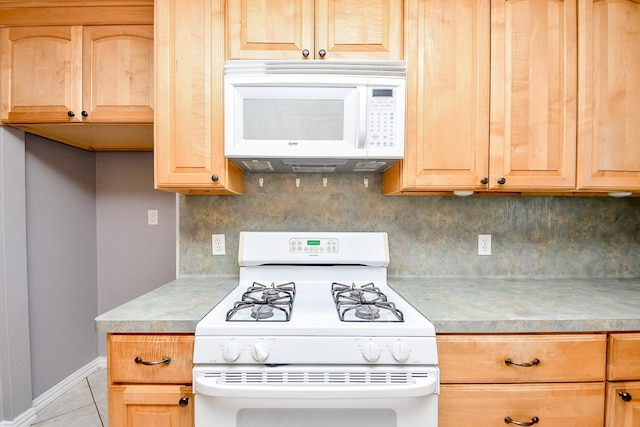 kitchen featuring decorative backsplash, light brown cabinets, white appliances, and light tile patterned floors