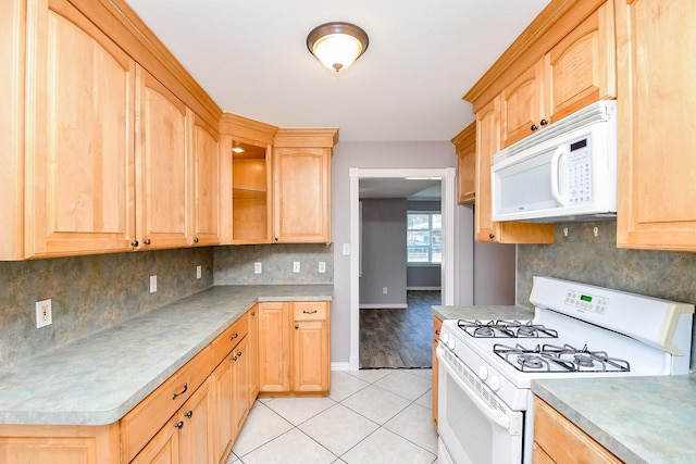 kitchen with light tile patterned floors, white appliances, and tasteful backsplash