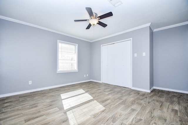 unfurnished bedroom featuring ceiling fan, a closet, light hardwood / wood-style floors, and ornamental molding