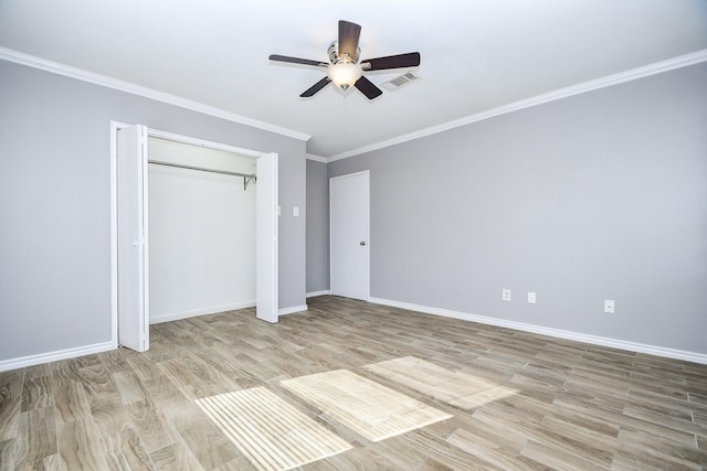 unfurnished bedroom with light wood-type flooring, a closet, ceiling fan, and crown molding