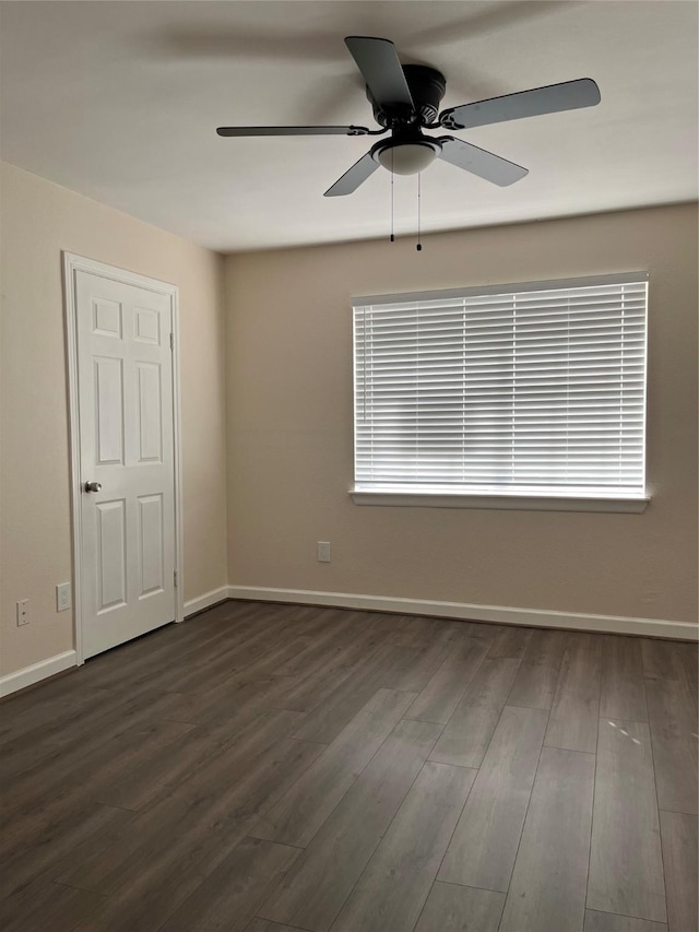 unfurnished room with a healthy amount of sunlight, ceiling fan, and dark wood-type flooring