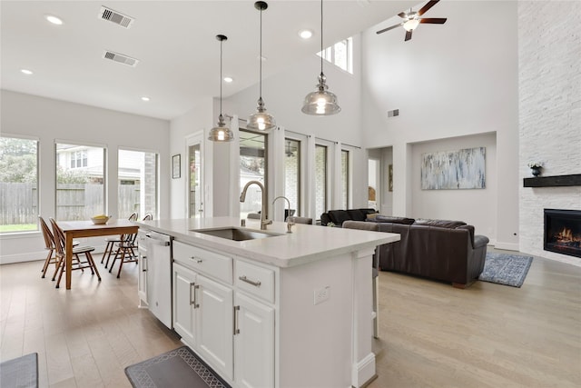 kitchen with white cabinets, a towering ceiling, sink, and a wealth of natural light