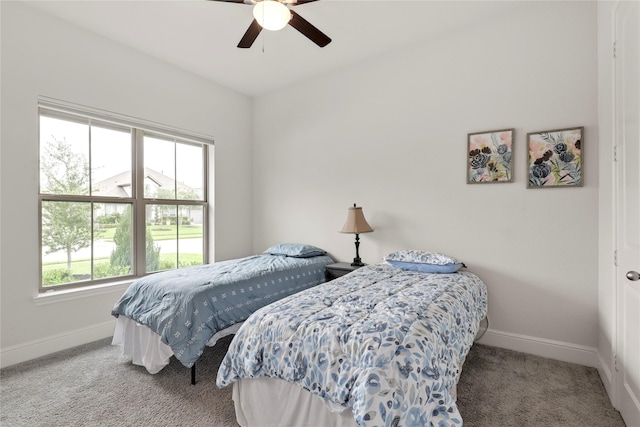 carpeted bedroom featuring multiple windows and ceiling fan