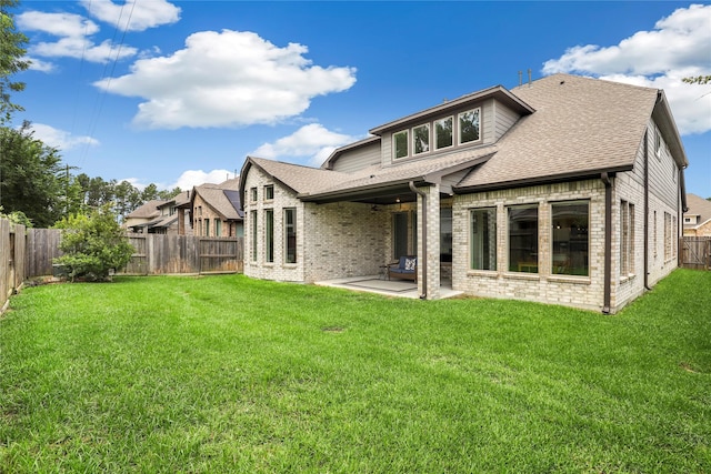 back of property with a yard and a patio