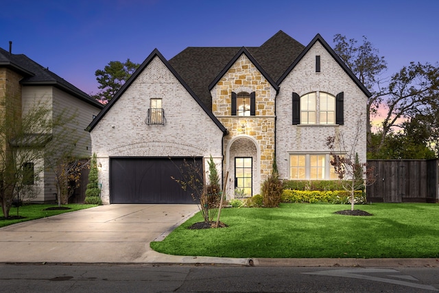 french country home with a yard and a garage