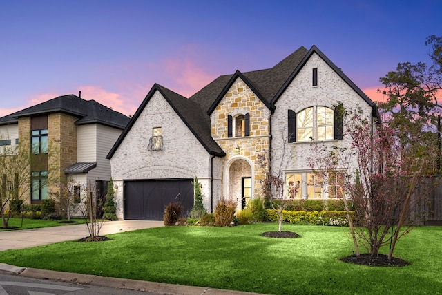 view of front of property featuring a garage and a lawn