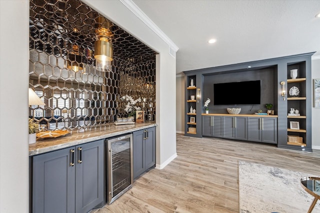 bar with light hardwood / wood-style floors, wine cooler, crown molding, and light stone counters