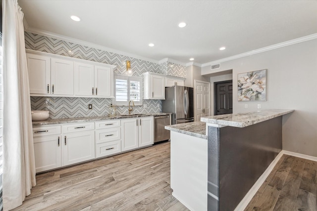 kitchen with white cabinets, light hardwood / wood-style floors, sink, and appliances with stainless steel finishes