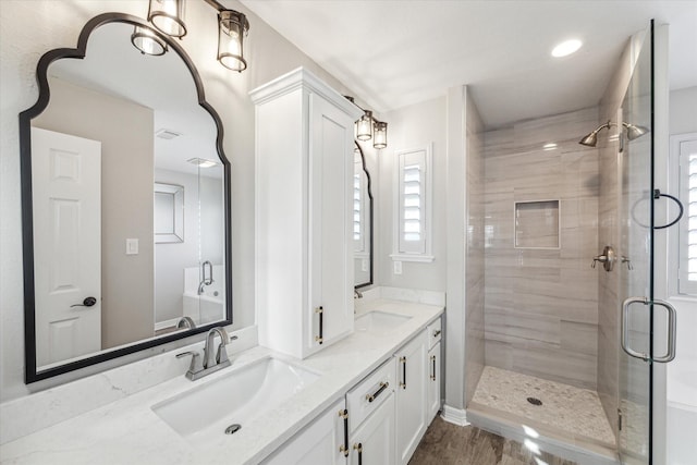 bathroom featuring vanity, hardwood / wood-style flooring, and a shower with shower door