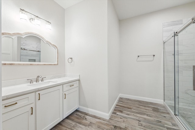 bathroom with hardwood / wood-style flooring, vanity, and a shower with door