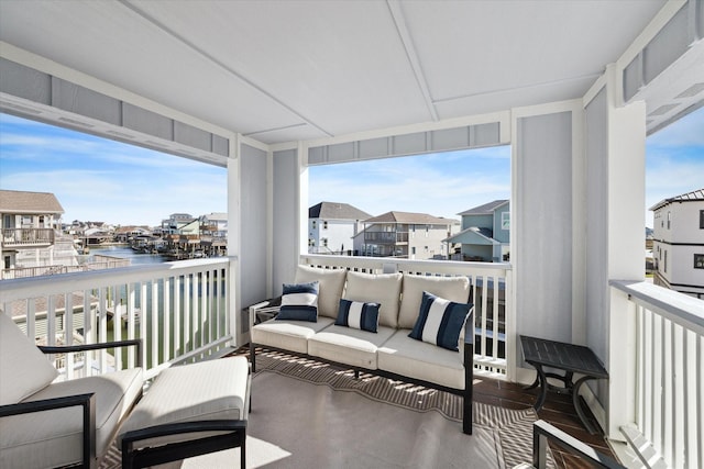 balcony with an outdoor living space and a water view