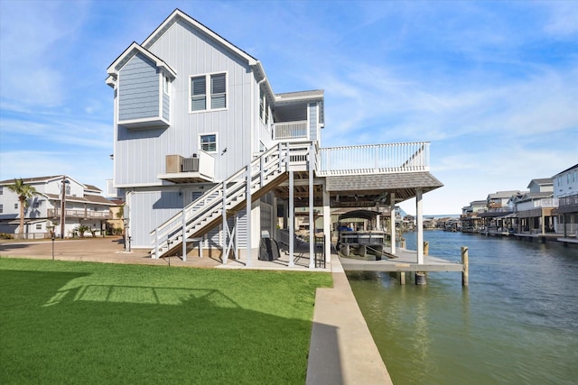 rear view of property with a lawn and a deck with water view