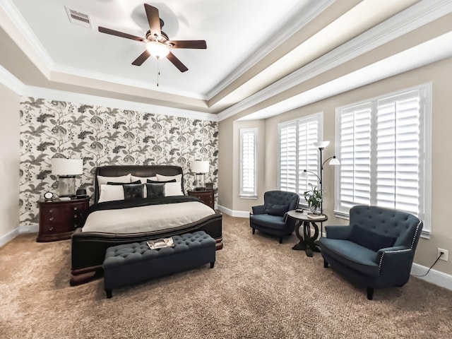 carpeted bedroom with a tray ceiling, ceiling fan, and ornamental molding