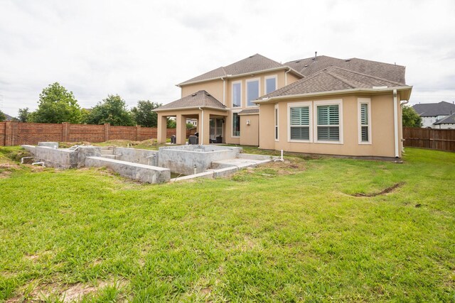 rear view of property featuring a patio and a lawn