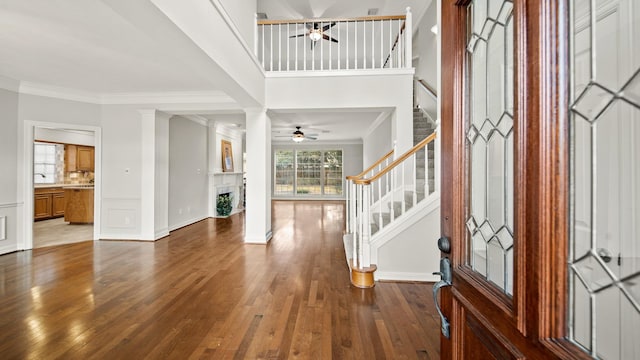 foyer with decorative columns, crown molding, ceiling fan, and hardwood / wood-style flooring