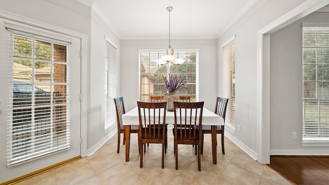 dining area featuring a notable chandelier, light tile patterned floors, and crown molding