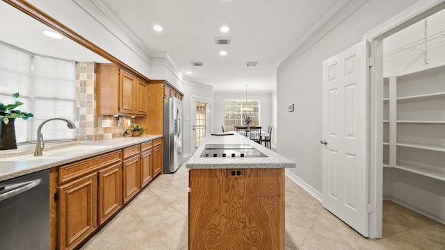 kitchen with sink, stainless steel appliances, decorative backsplash, a kitchen island, and ornamental molding