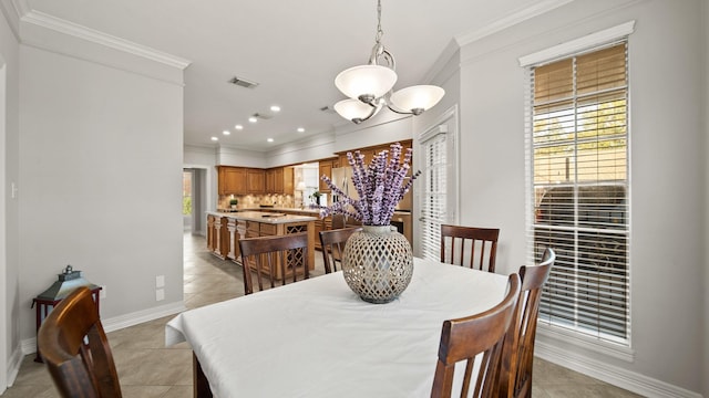 tiled dining room with a healthy amount of sunlight, crown molding, and an inviting chandelier