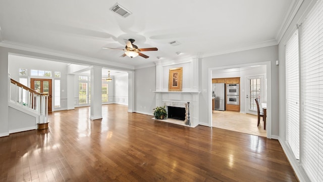 unfurnished living room with hardwood / wood-style flooring, ceiling fan, ornamental molding, and decorative columns