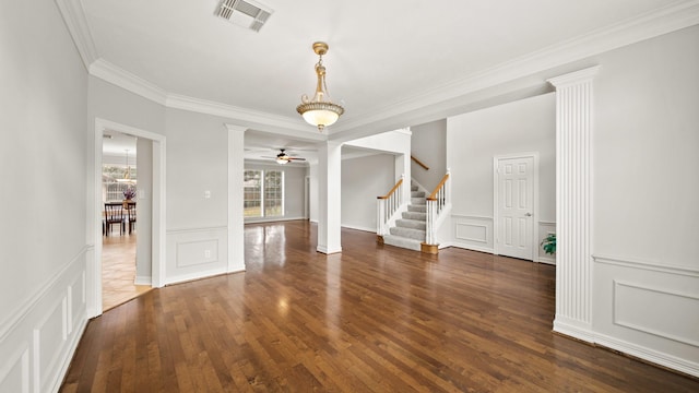 spare room featuring ceiling fan, ornamental molding, dark wood-type flooring, and decorative columns