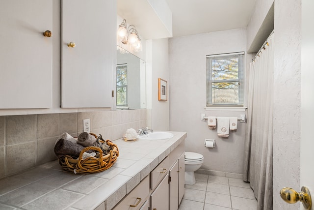 bathroom with tile patterned flooring, vanity, tasteful backsplash, and toilet