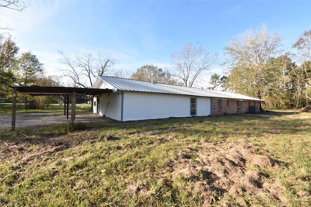 view of side of property with a carport and a yard