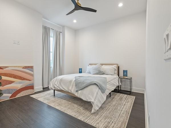 bedroom with dark hardwood / wood-style flooring and ceiling fan