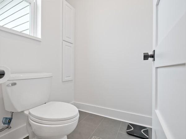 bathroom featuring toilet and tile patterned flooring