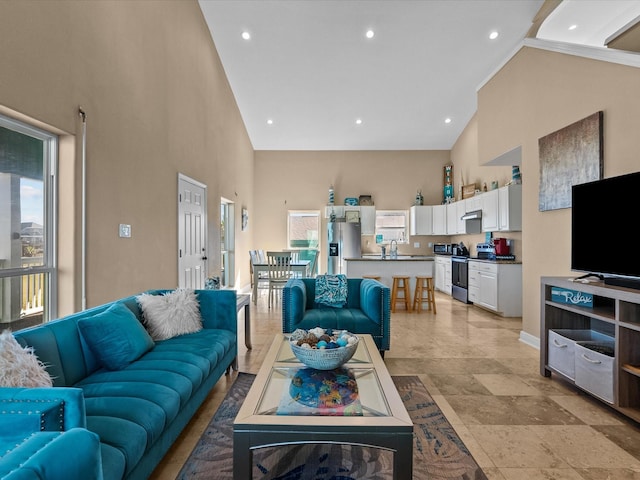 living room featuring sink and high vaulted ceiling