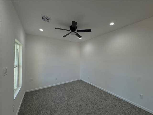 unfurnished room with ceiling fan and dark carpet