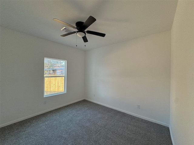 empty room with ceiling fan and dark carpet