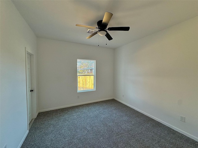 empty room featuring ceiling fan and dark colored carpet